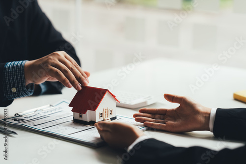 Buying a Home or Insurance, an insurance agent explains the lease agreement to a client before making a contract. Mortgage loan approval home loan and insurance concept.