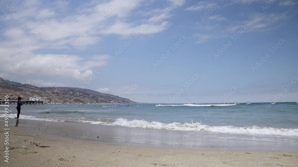 Woman surfer looking after other surfers in the ocean Woman surfer looking after other surfers in the ocean