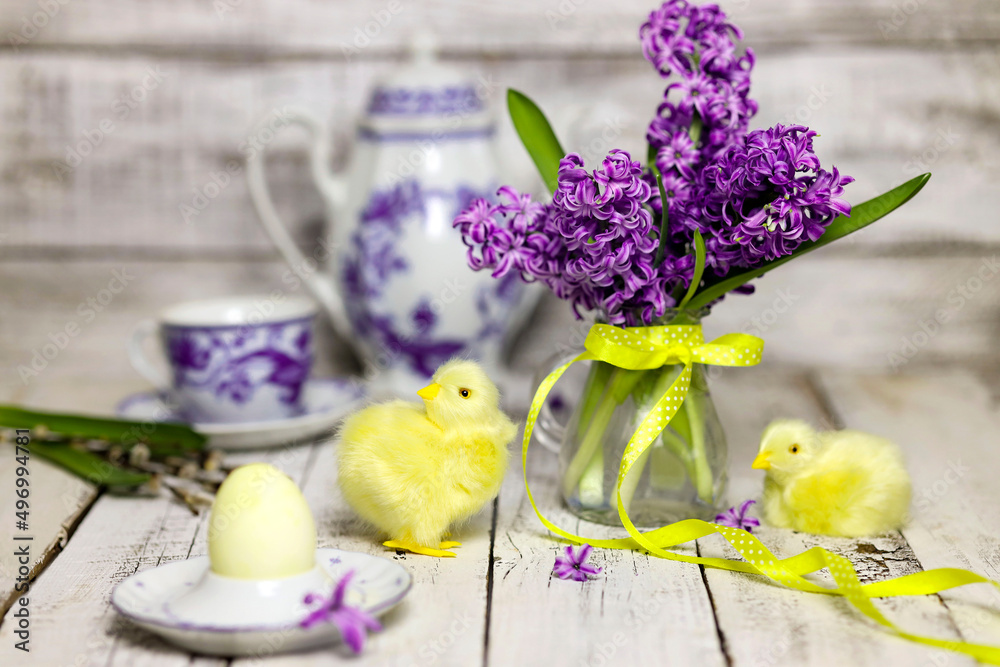 Easter breakfast table with tea,eggs in egg cups, spring flowers in vase and Easter decor.