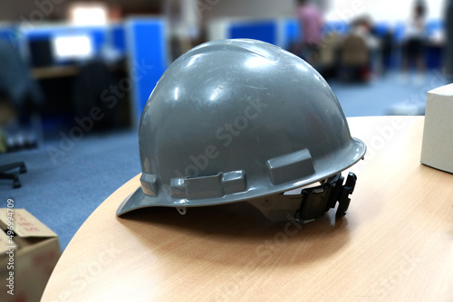 Gray safety helmet on the table in the construction office 