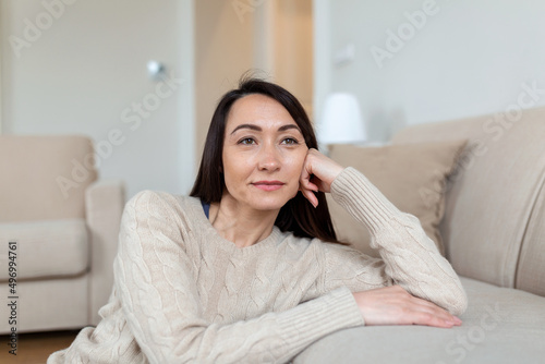 Portrait of smiling middle aged Asian woman looking at camera. Beautiful woman smiling at home.