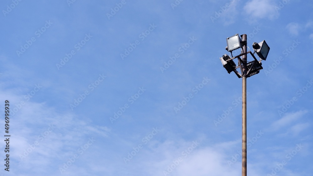 Stadium halogen spot light pole with blue sky background Stadium halogen spot light pole with blue sky background