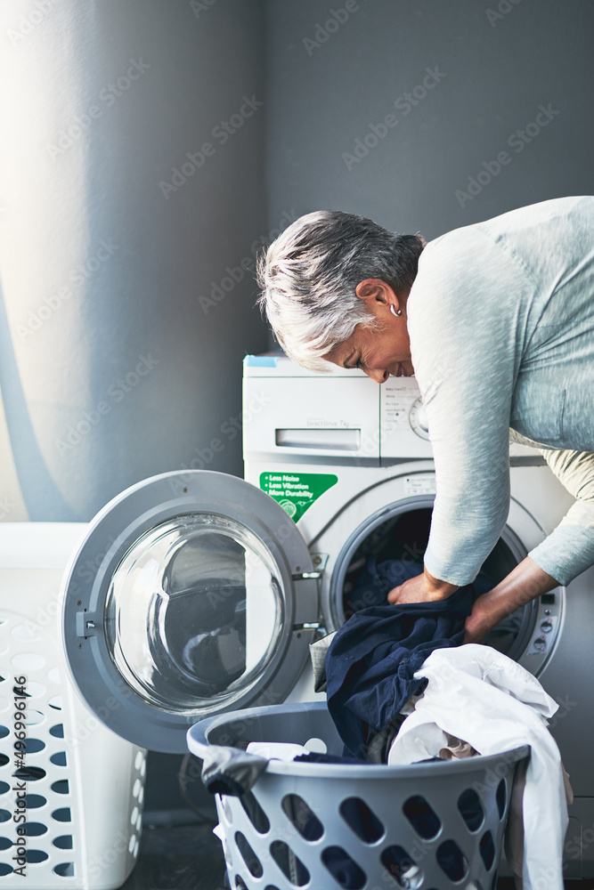 Lets get down to laundering business. Shot of a mature woman doing laundry at home.