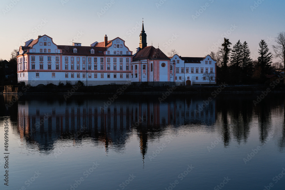 Neuhaus Castle is reflected in the evening light on the surface of the Inn.