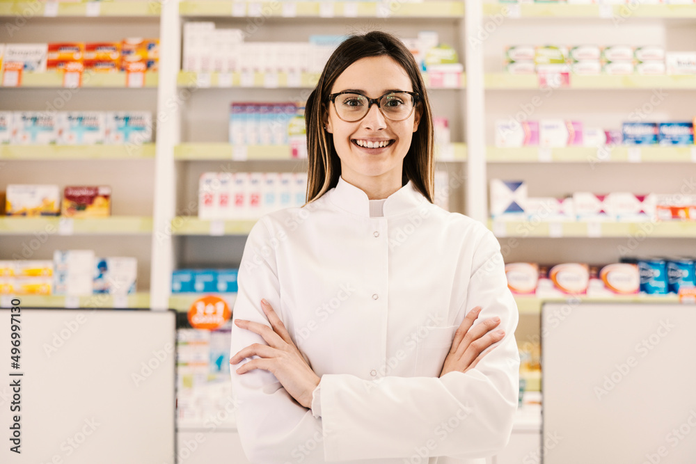 A female pharmacy worker standing proudly and smiling at the camera. A female pharmacy worker standing proudly and smiling at the camera.