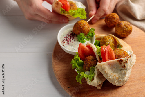 pita bread with falafel, meatballs. Street food with falafel. Hands holding falafel on a skewer