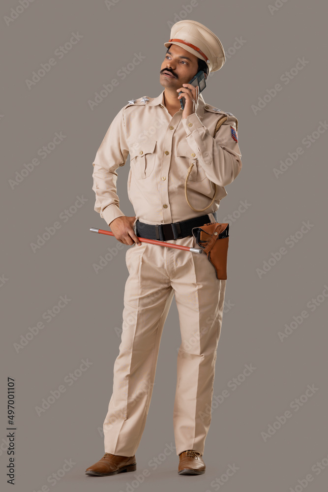Portrait of an Indian policeman talking on smartphone Portrait of an Indian policeman talking on smartphone