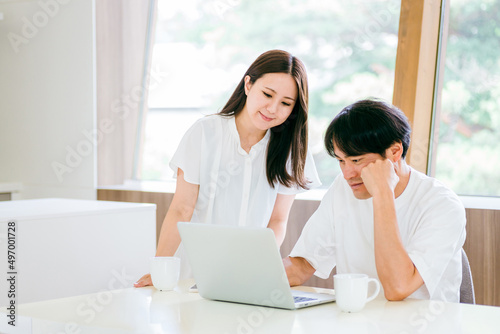 ダイニングでテレワークする男女 