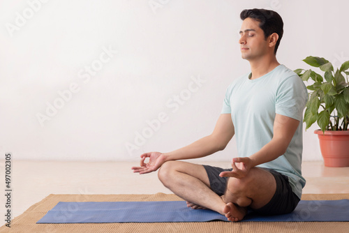 Portrait of a young man meditating at home