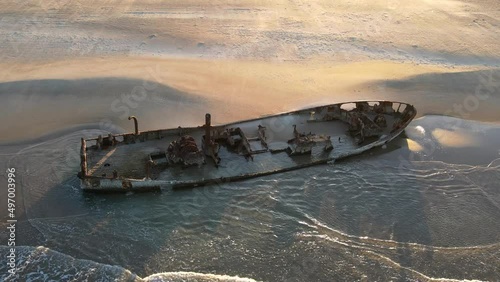 Aerial view of wrecked boat, on the shoreline , on the beach in Moshav Habonim old shipwreck in Habonim beach in Israel. photo