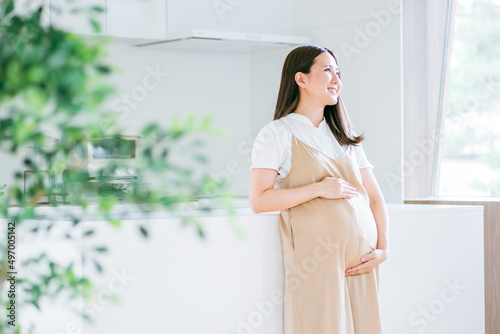 キッチンの前に立つ妊婦 