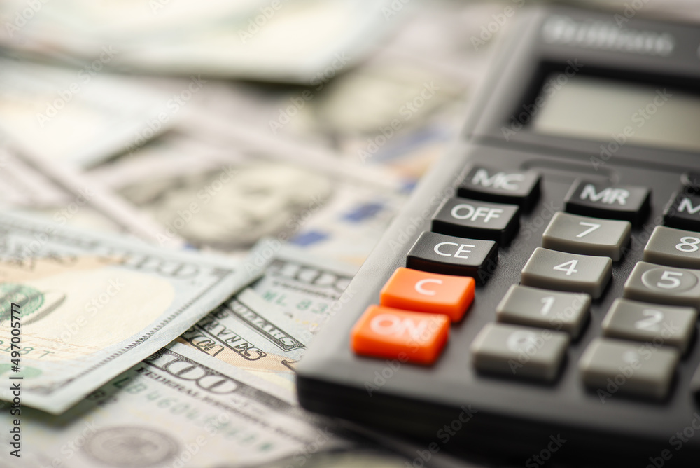 Close up photo of calculator and dollar banknotes Close up photo of calculator and dollar banknotes