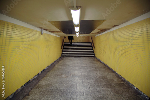 Pedestrian subway leading to Underground Trains in Berlin. Run-down, retro styled with converging Lines and fluorescent lighting. photo