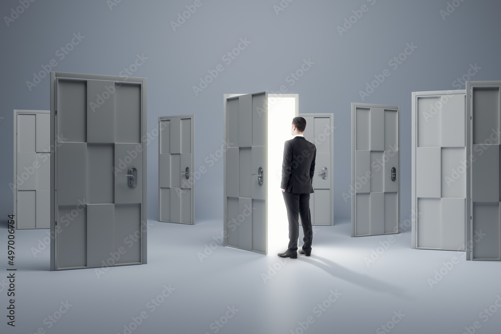 Man standing in front of abstract white puzzle door in interior. Future, choice, success, direction, opportunity and solution concept. Man standing in front of abstract white puzzle door in interior. Future, choice, success, direction, opportunity and solution concept.