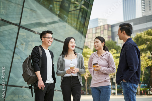 Photography group of young asian adults men and women standing talking on street