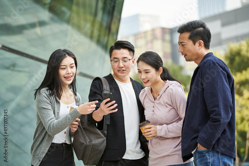 group of young asian people looking at cellphone together