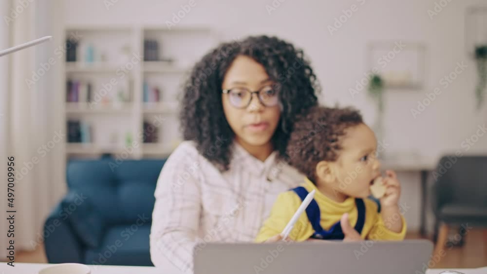 Mother talking at online conference, holding kid on knees, unpaid parental leave Mother talking at online conference, holding kid on knees, unpaid parental leave