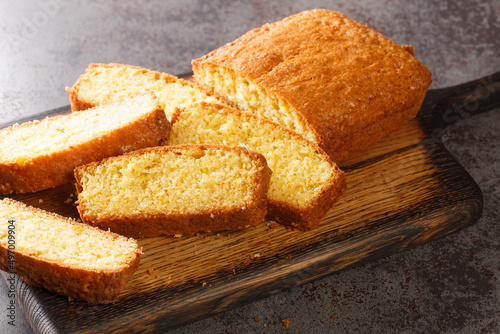 Photography Tasty Madeira sponge cake closeup served on a wooden cutting board on the concrete table