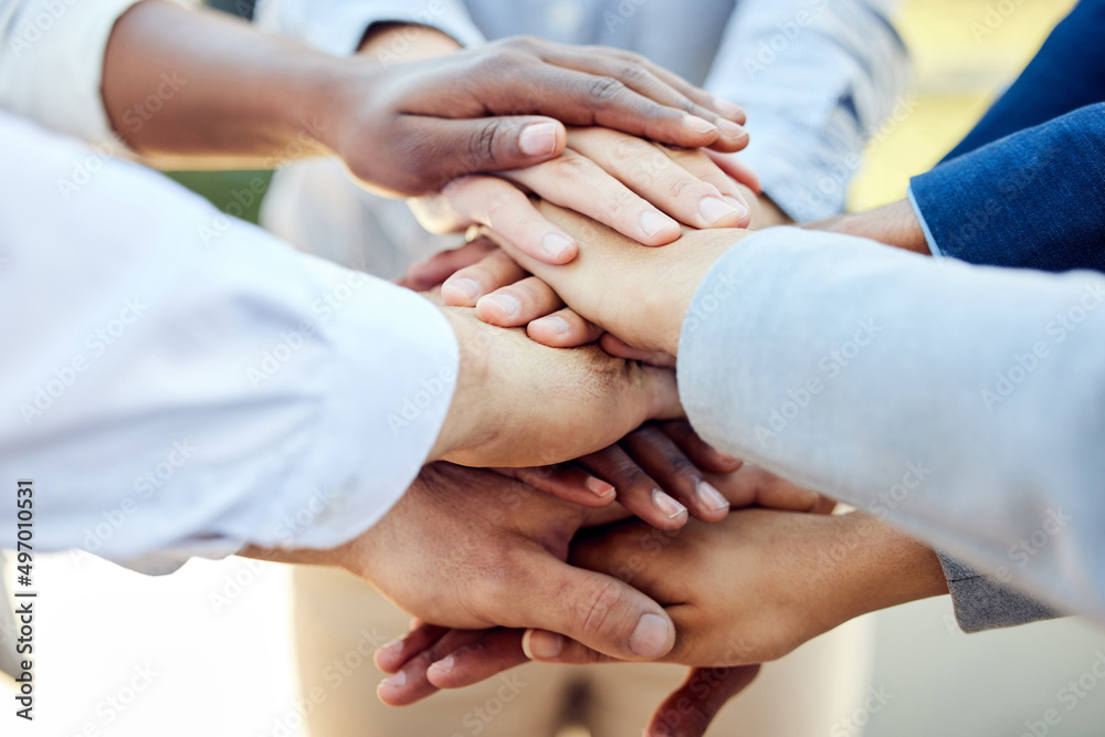 Never alone without love. Shot of a group of unrecognizable businesspeople stacking their hands together outside. Never alone without love. Shot of a group of unrecognizable businesspeople stacking their hands together outside.
