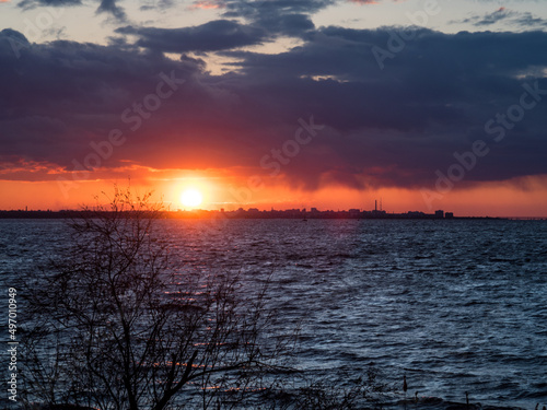 Amazing fiery red sunset over the city. Sunset between cloud and city