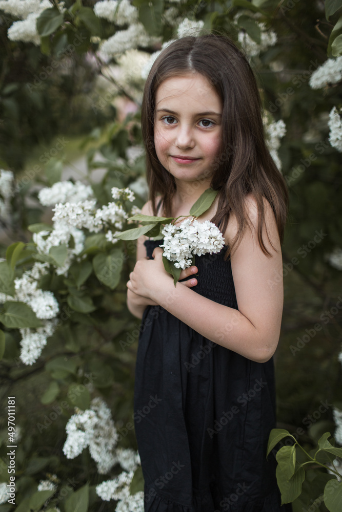 little girl with lilac walks in the park