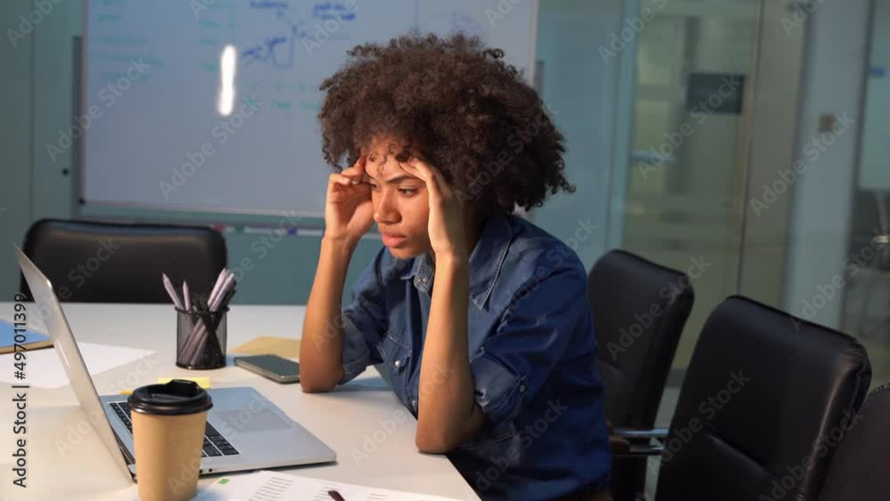 overworked tired woman is holding her head with headache in evening modern cabinet overworked tired woman is holding her head with headache in evening modern cabinet