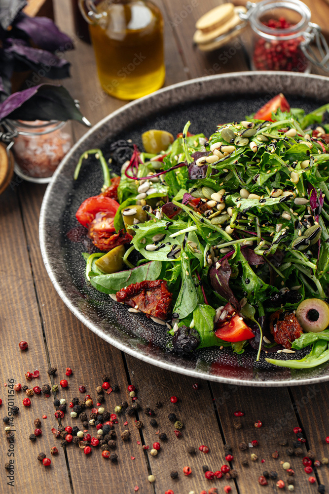 Green mediterranean salad with pine nuts and sun-dried tomatoes