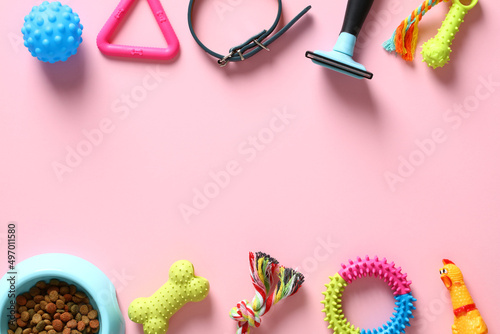 Flat lay composition with pet accessories and bowl of dry food on pink background. Pet care and training concept. Pet shop banner design.