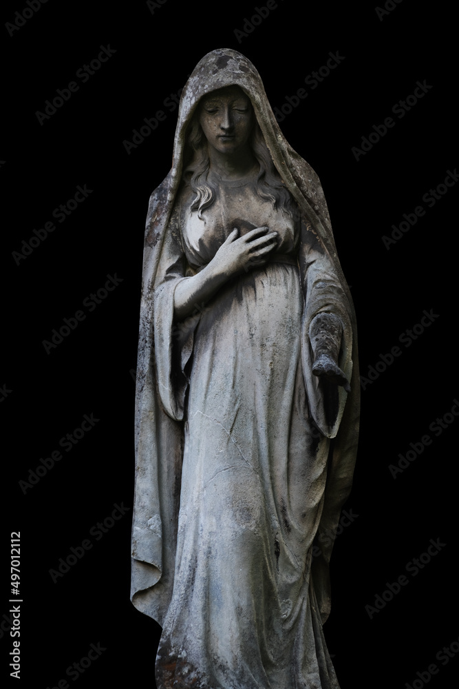 Virgin Mary. Ancient statue isolated on black background.