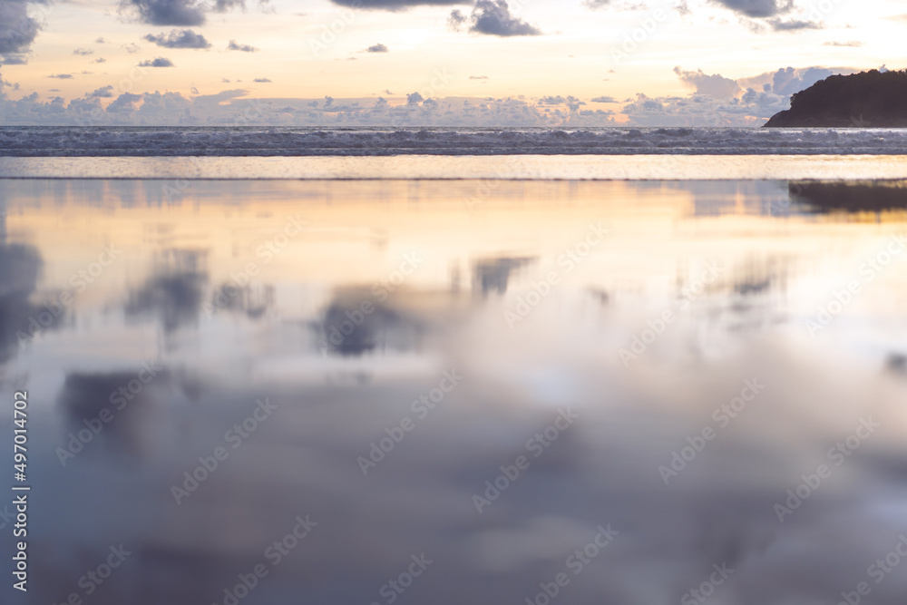 Sea wave and beach sand with refection of sky on sunset time nobody background.