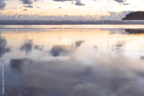 Sea wave and beach sand with refection of sky on sunset time nobody background.