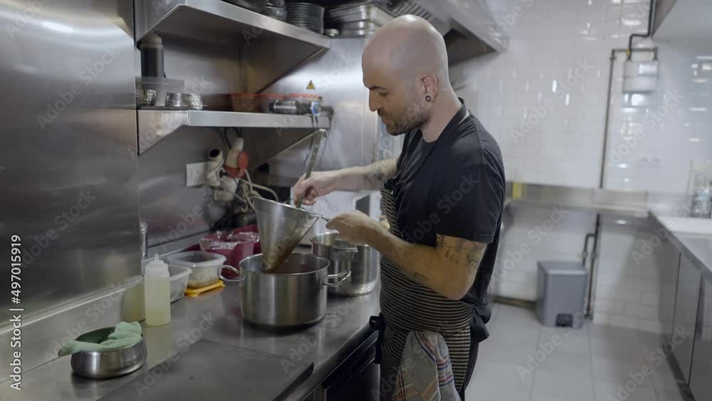 Half body side view of male chef working in restaurant kitchen Half body side view of male chef working in restaurant kitchen
