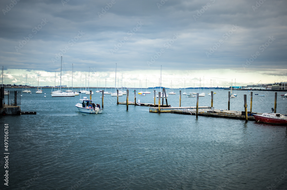 wooden pier in the port full of  sailing yachts view of the Boston main channel