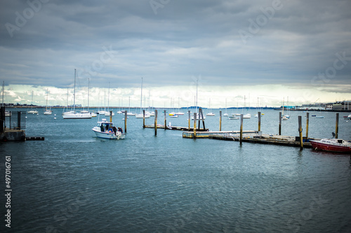 wooden pier in the port full of  sailing yachts view of the Boston main channel © Alevtina