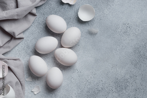 White eggs with eggshells on a concrete table