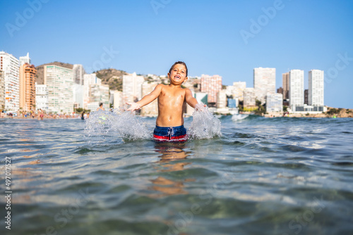 Konstfotografi Funny kid spalshing water on an urban beach