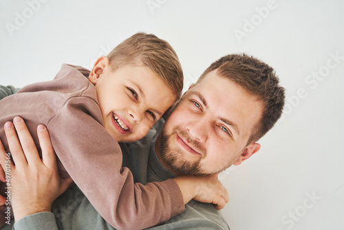 Close-up portrait of smiling father and son. Handsome dad and cheerful and emotional kid. Paternity.