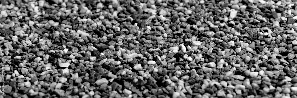 The pattern of small black pebbles stone. Panoramic background The pattern of small black pebbles stone. Panoramic background