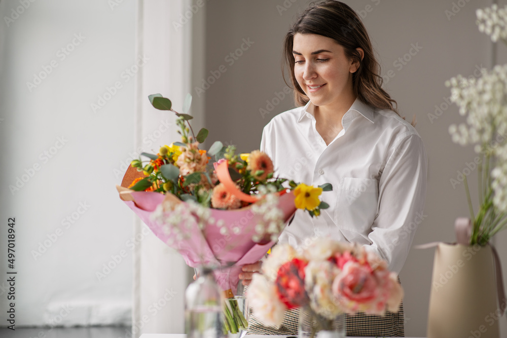 people, gardening and floral design concept - happy woman or floral artist arranging flowers in vase at home people, gardening and floral design concept - happy woman or floral artist arranging flowers in vase at home