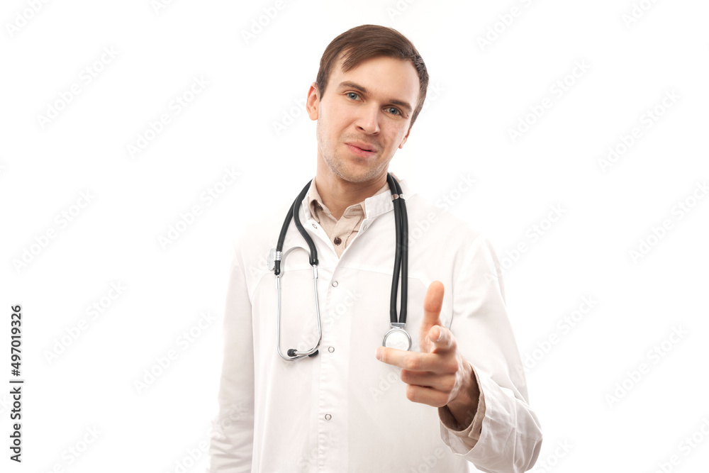Portrait of friendly positive young male doctor in white medical coat chooses you, points finger at camera isolated on white background. Portrait of friendly positive young male doctor in white medical coat chooses you, points finger at camera isolated on white background.