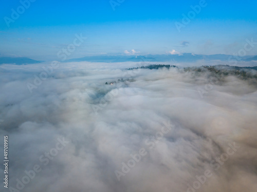 High flight above the clouds in the mountains. Aerial drone view.