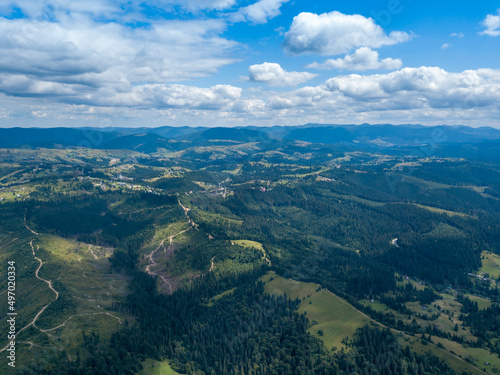 Green mountains of Ukrainian Carpathians in summer. Coniferous trees on the slopes. Aerial drone view.