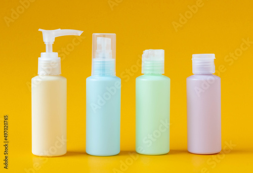 A set of mini travel bottles approved for air travel. Set of empty containers for cosmetics on a yellow background, side view