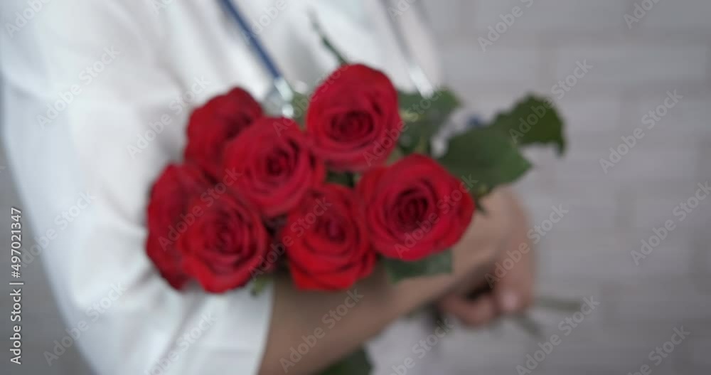 Roses day for doctor. Beautiful roses lay in doctor's hands in the room. A concept of present for International doctor's day. Roses day for doctor. Beautiful roses lay in doctor's hands in the room. A concept of present for International doctor's day.