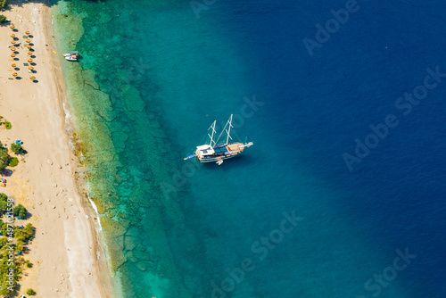 Amazing aerial view of Butterfly Valley in Fethiye Turkey. Summer landscape with mountains, green forest, azure water, sandy beach and blue sky in bright sunny day. Travel background. Top view. Nature © Birol