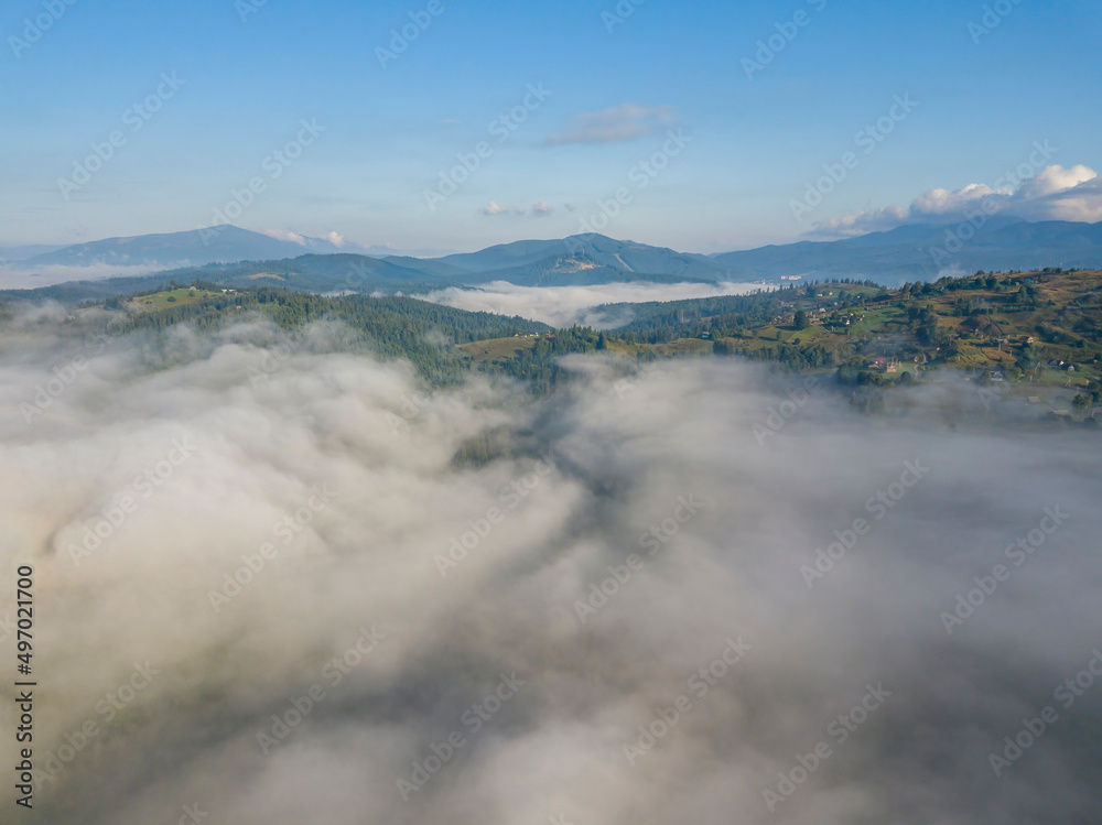 High flight above the clouds in the mountains. Aerial drone view.