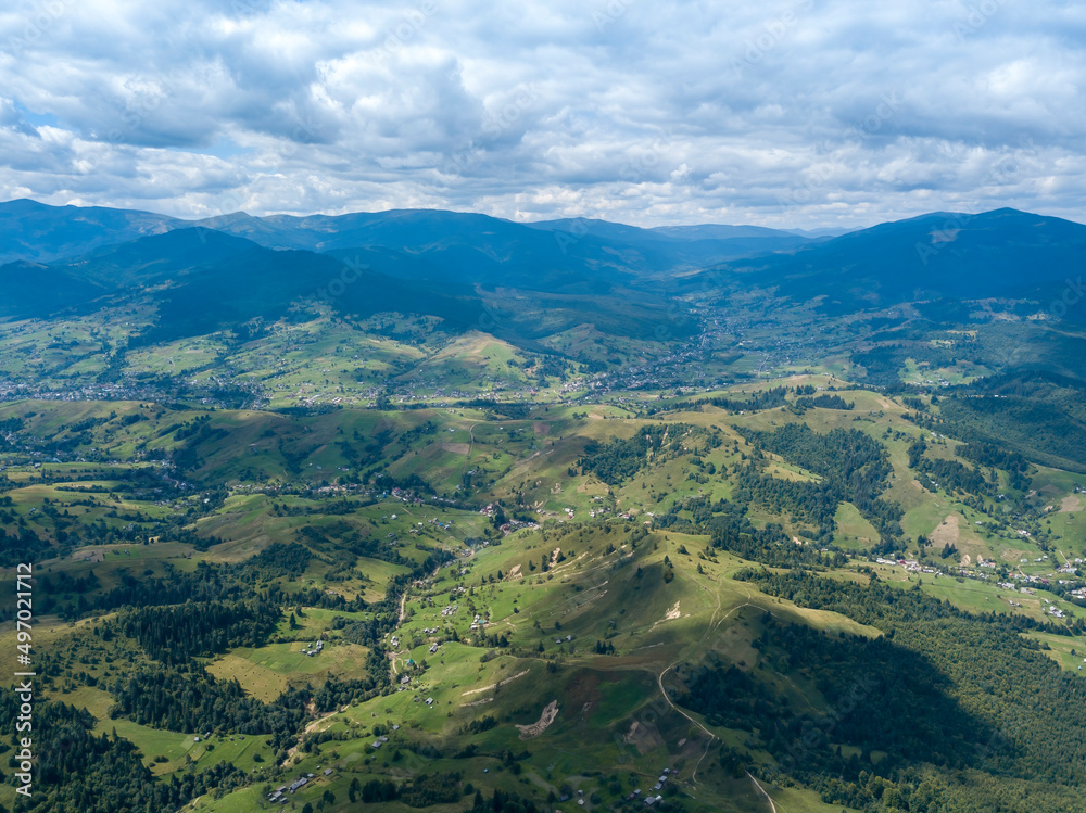 Naklejka premium Green mountains of Ukrainian Carpathians in summer. Coniferous trees on the slopes. Aerial drone view.