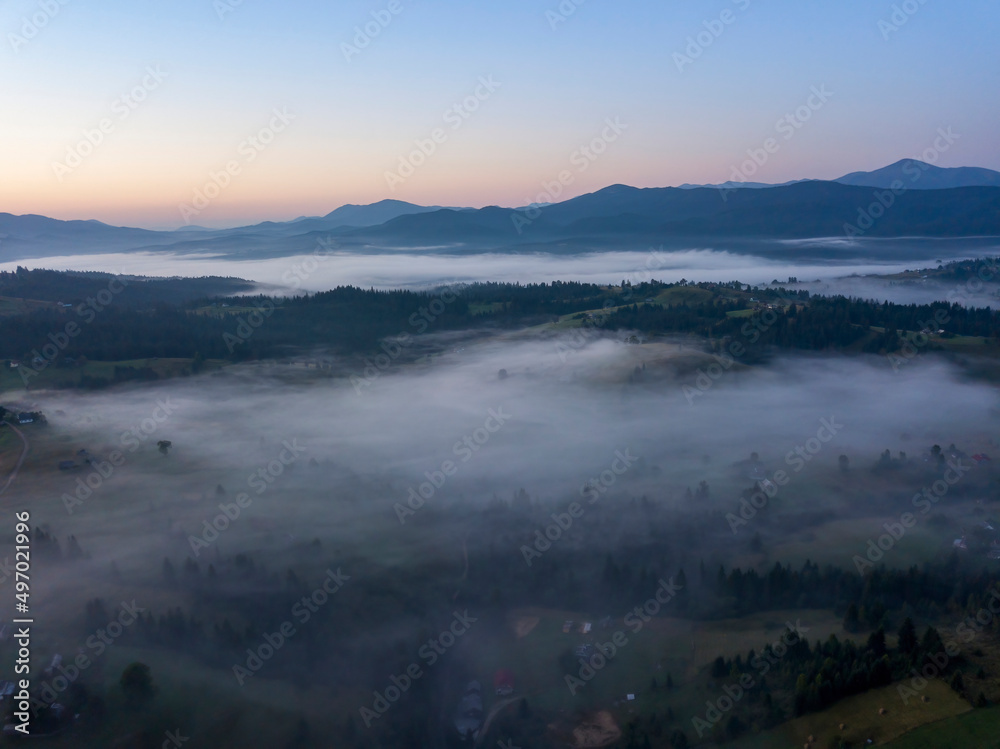 Morning mist in Ukrainian Carpathian mountains. Aerial drone view.