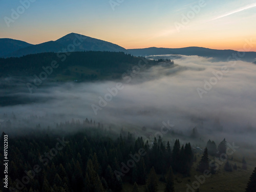 Green mountains of the Ukrainian Carpathians in the morning mist. Aerial drone view.