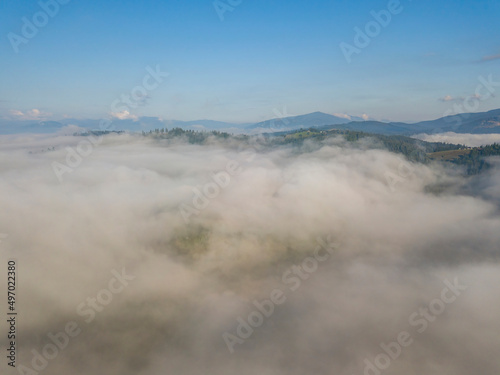 High flight above the clouds in the mountains. Aerial drone view.